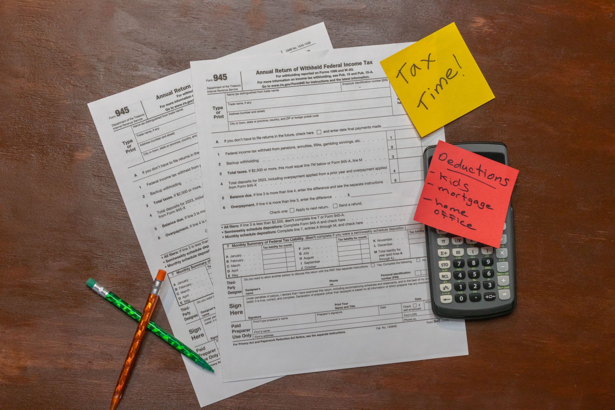 Tax forms, calculator, sticky notes, and pencils.